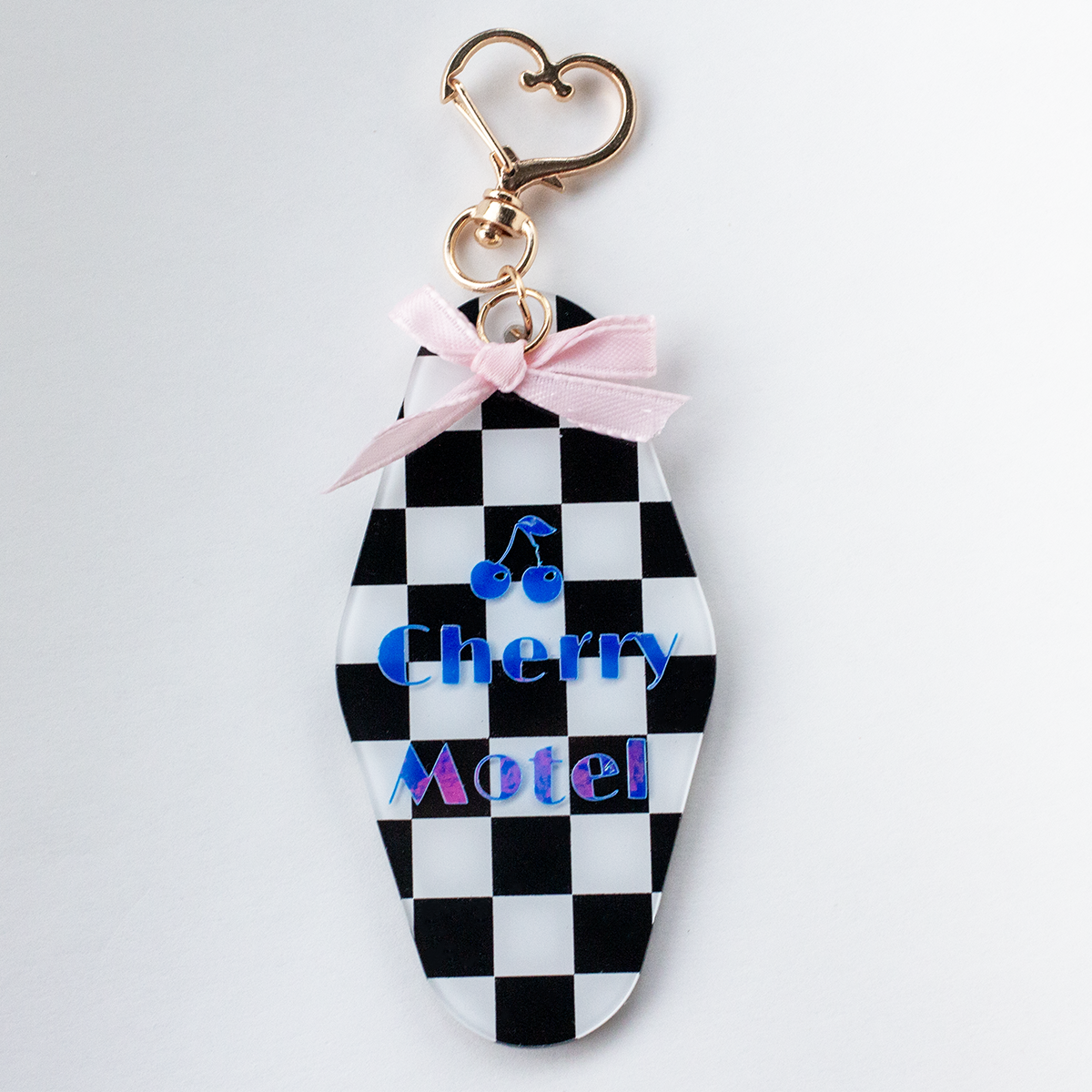 Retro motel style acrylic keychain with black and white checkered pattern, pink bow, and cherry charm – cute Valley Dolls accessory