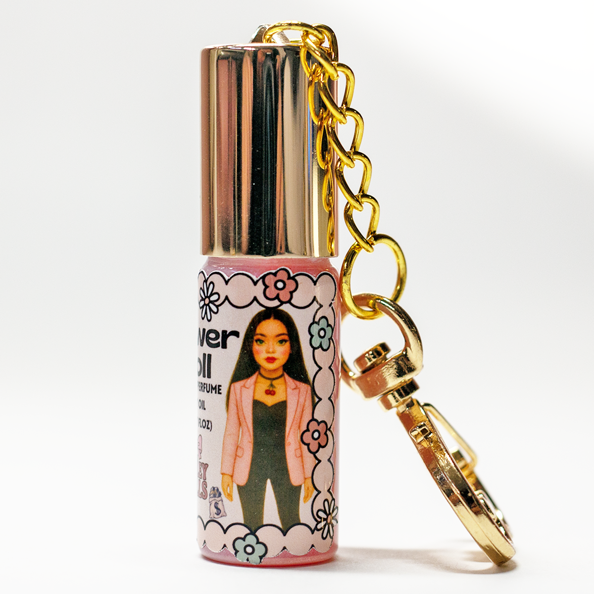 Power Doll bold floral perfume oil roll-on in 5ml glass bottle with gold heart keychain clasp