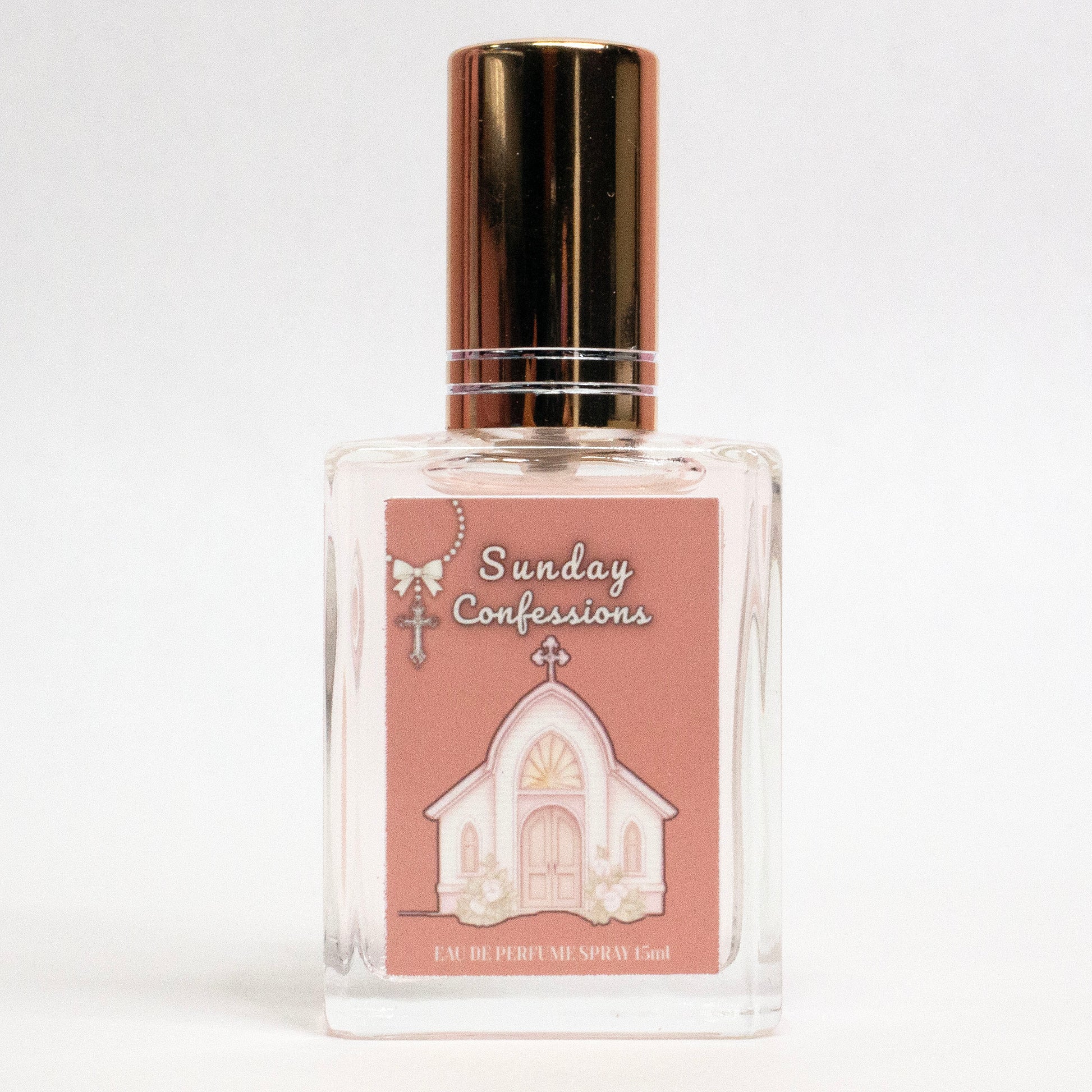 Valley Dolls Sunday Confessions limited edition perfume spray shown in a clear glass bottle with a church illustration label, photographed on a white background.