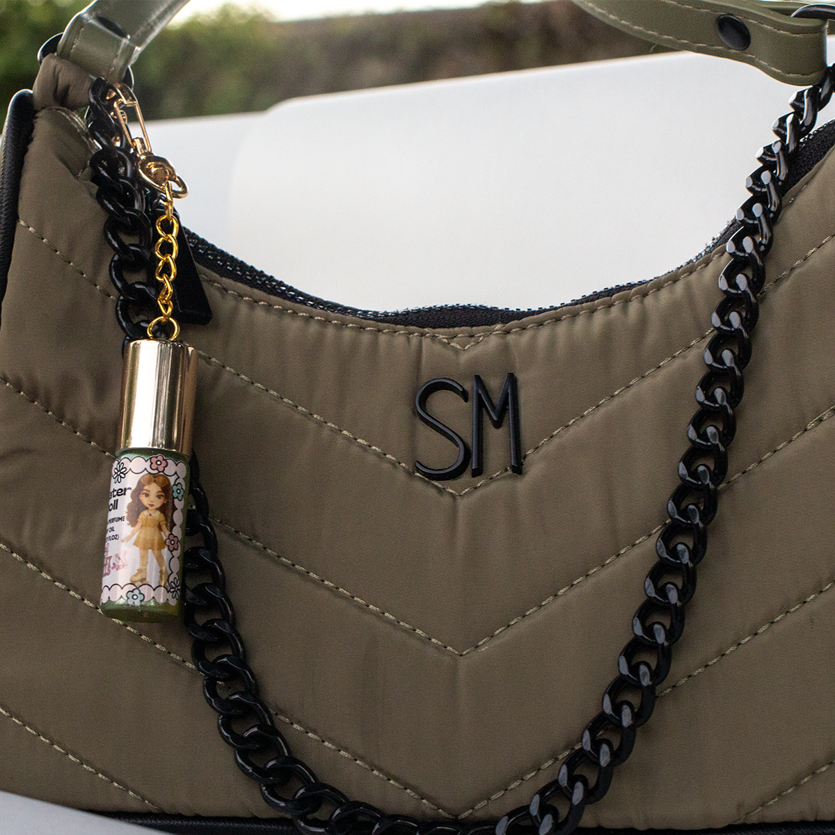 Skater Doll fruity perfume oil roll-on, 5 ml glass bottle with gold heart keychain clasp, attached to handbag with black chain – The Valley Dolls fragrance