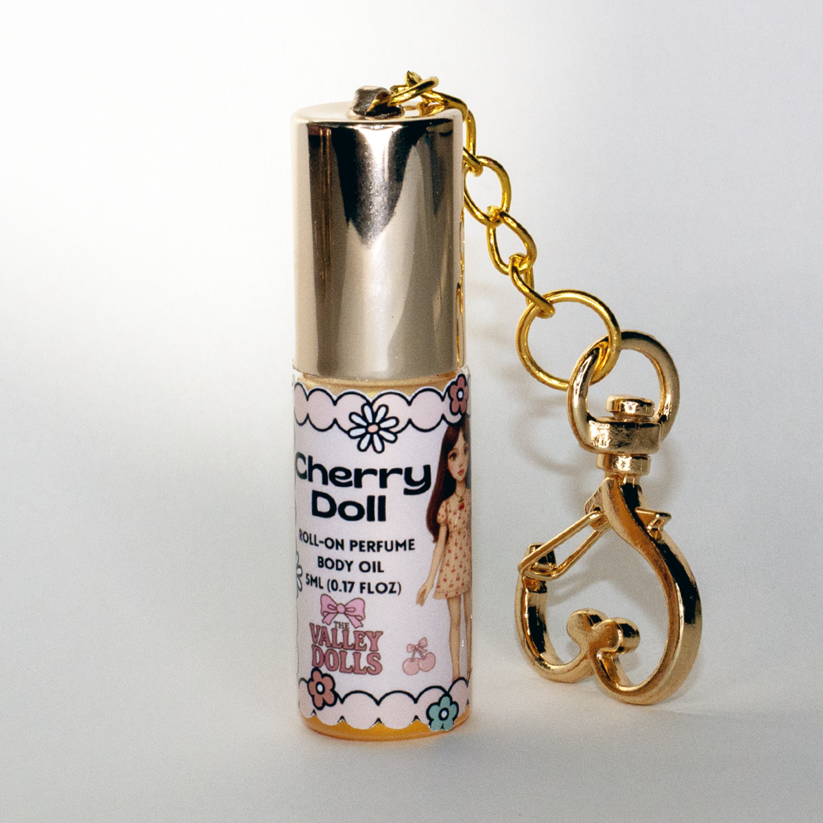 Cherry Doll perfume oil roll-on, 5 ml portable fragrance bottle with gold heart keychain clasp – tart berry and vanilla candy scent from The Valley Dolls