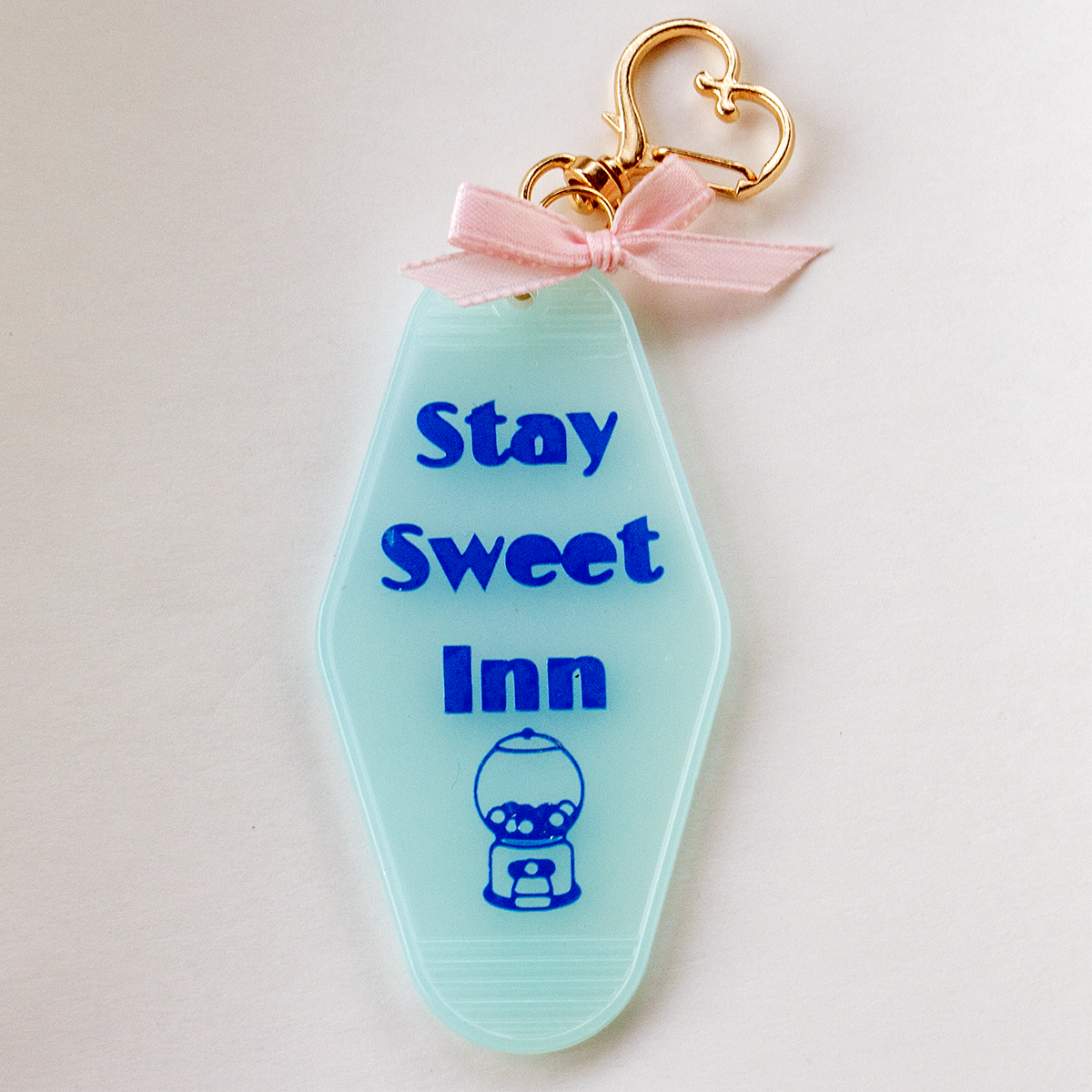 The Valley Dolls Stay Sweet Inn pastel blue motel keychain with gumball design and pink bow