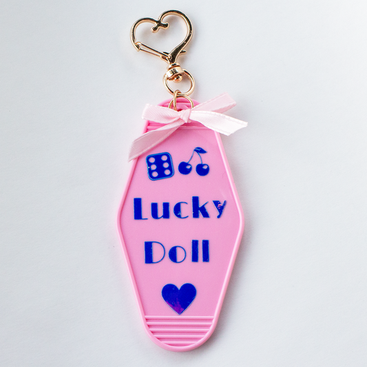 The Valley Dolls Lucky Doll pastel pink motel keychain with heart bow and gold clasp