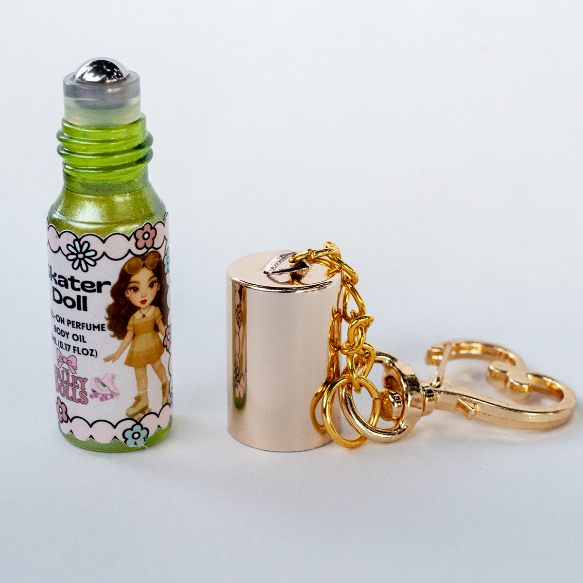 Noir Doll perfume oil roll-on, 5 ml glass bottle with rollerball applicator and gold heart keychain clasp – smoky sweet fragrance from The Valley Dolls
